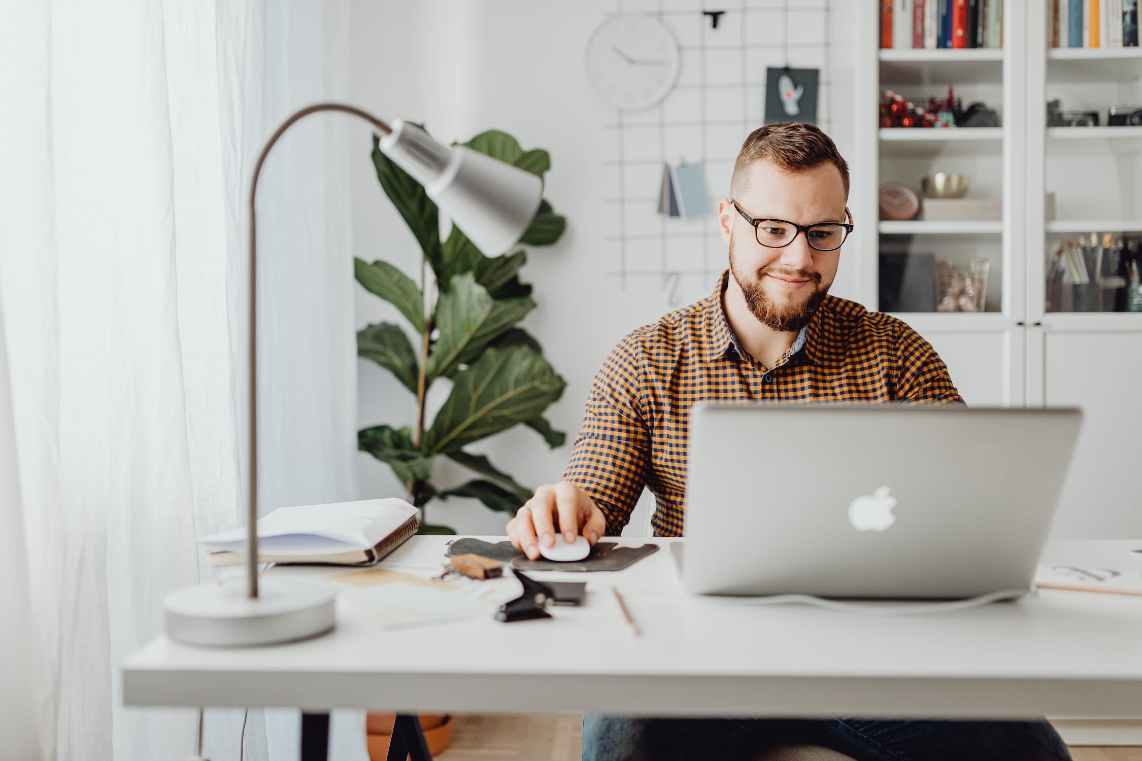 A man looking at his laptop on a desk