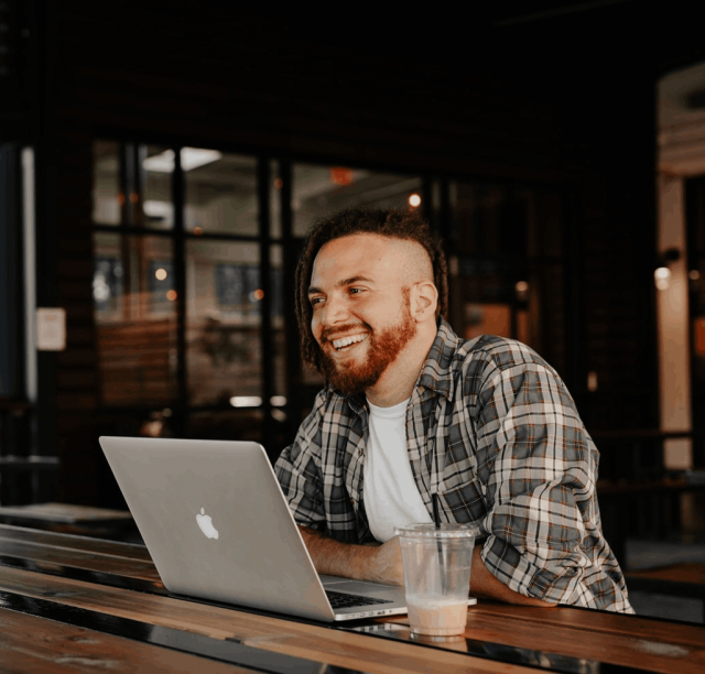 Man sitting at a table using his laptop